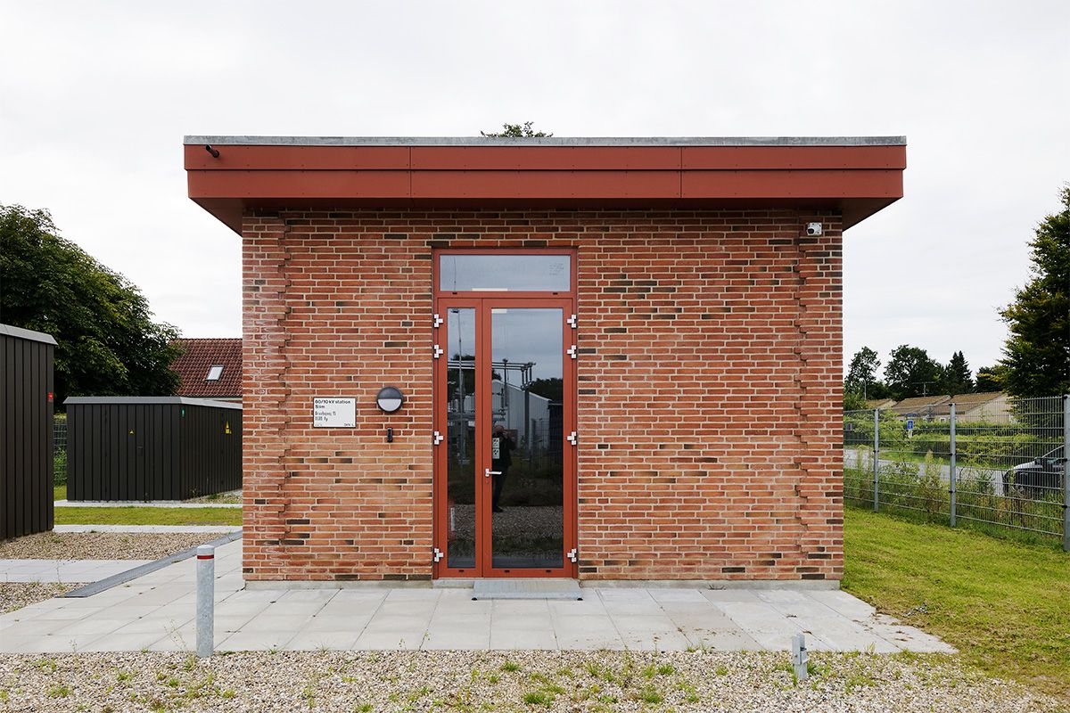 Transformerstation beklædt med røde tegl og et stort udhæng