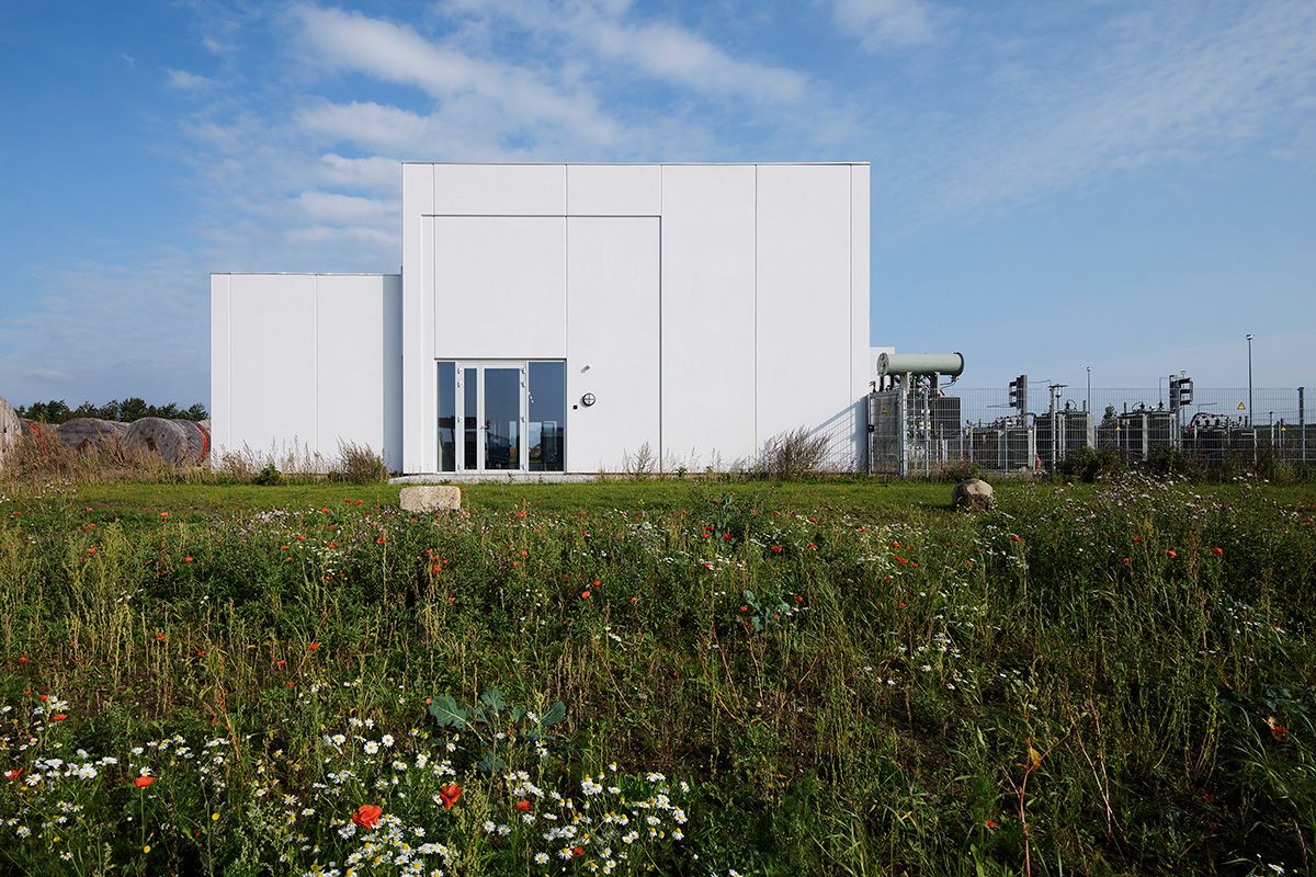 Transformerstation - Hvid bygning med græs i forgrunden