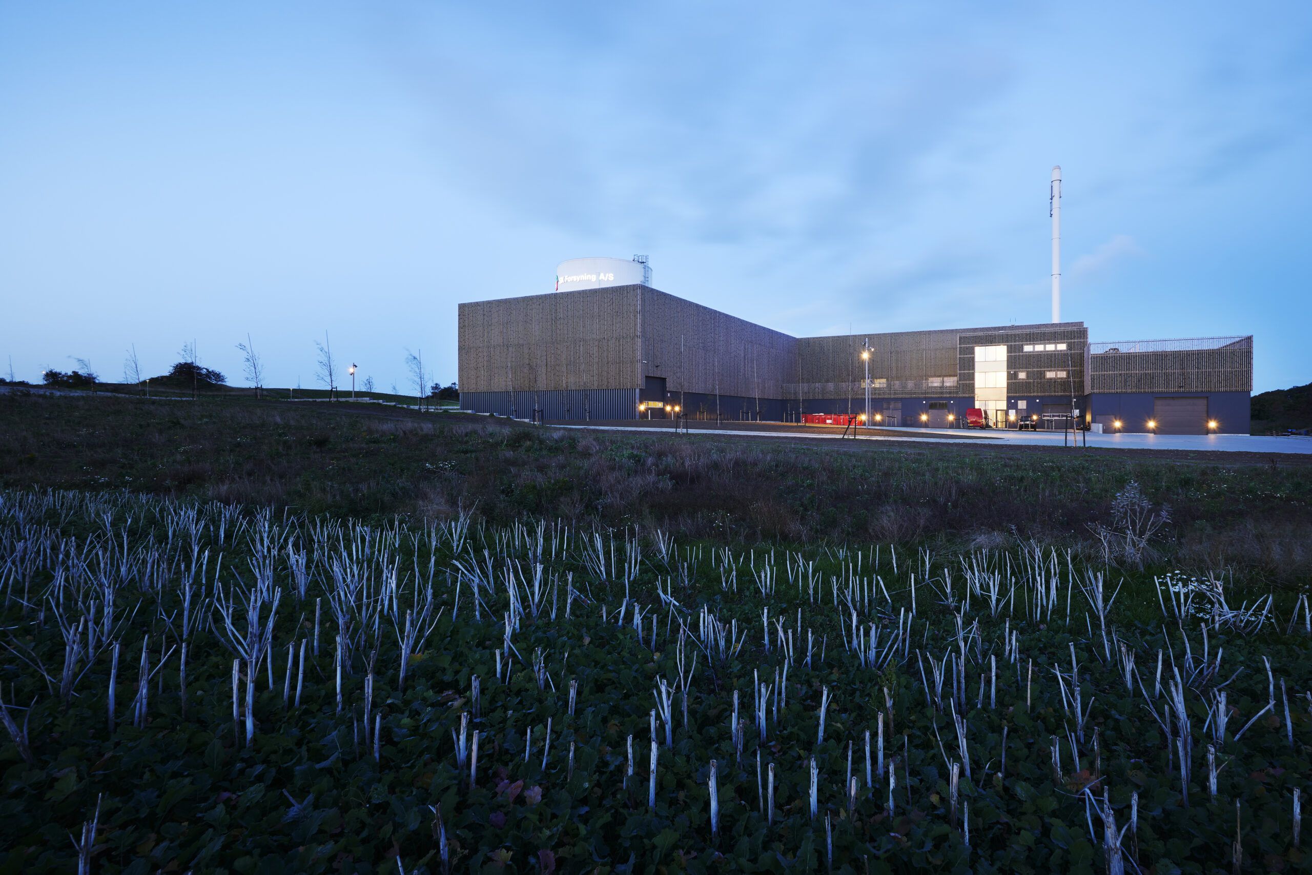 Varmeværket set i aftenlys med marker i forgrunden